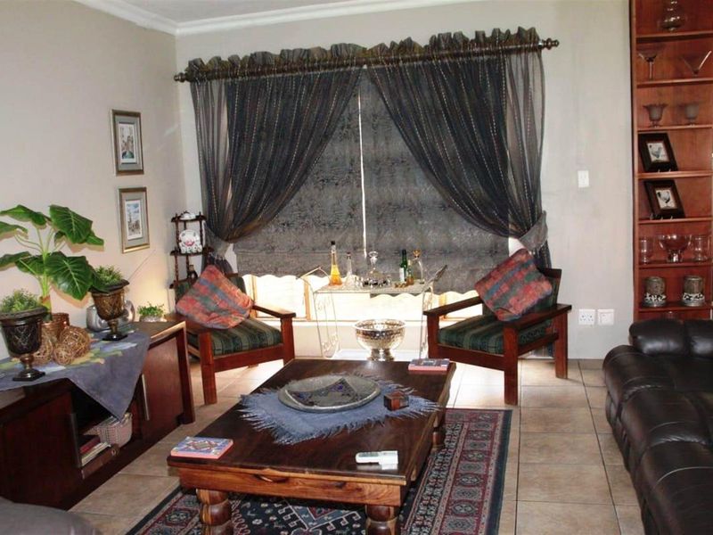A comfortable living room featuring tiled flooring and a built-in wooden display shelving unit.