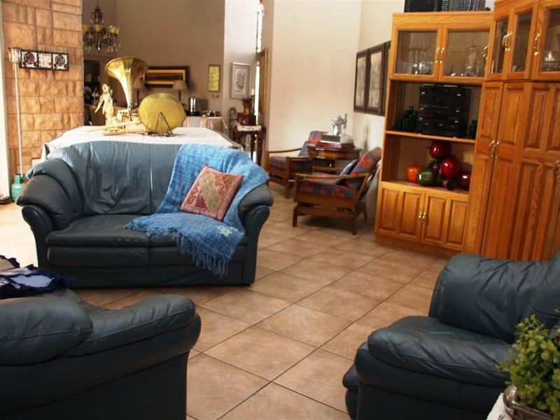 Spacious living area featuring tiled flooring and a prominent stone-clad feature wall, offering a warm and traditional aesthetic.