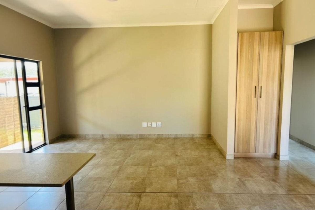 Spacious living area featuring neutral tiled flooring, built-in cabinetry, and sliding glass door access to the outdoor space.