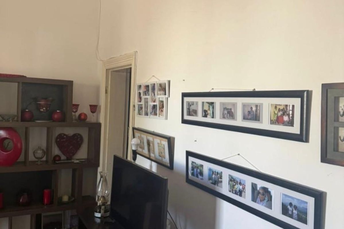 A living room area featuring high ceilings with decorative cornicing and timber skirting boards.