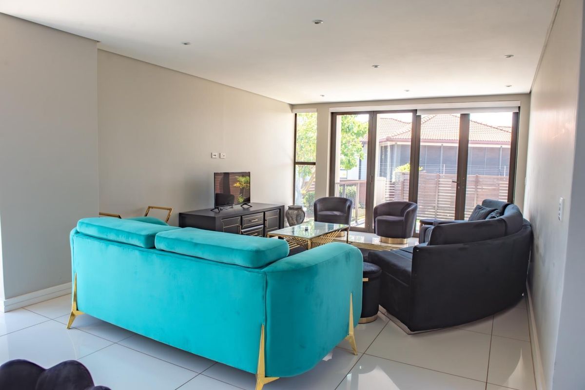 Spacious living room featuring large glass sliding doors that provide ample natural light and direct access to the outdoor area.