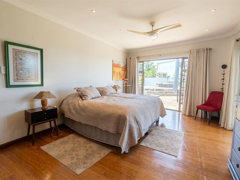 Spacious bedroom featuring hardwood flooring, recessed lighting, a ceiling fan, and direct access to an outdoor patio through sliding glass doors.