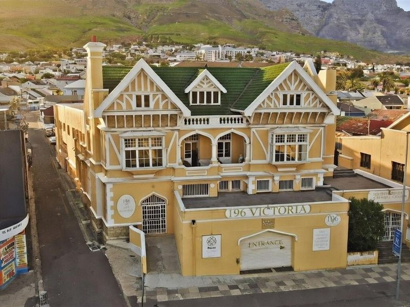 Aerial view of a commercial building featuring distinctive Tudor-style architecture, a green tiled roof, and a prominent street-level entrance.
