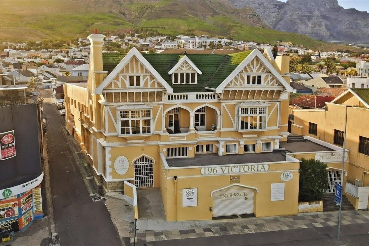 Aerial view of a commercial building featuring distinctive Tudor-style architecture, a green tiled roof, and a prominent street-level entrance.