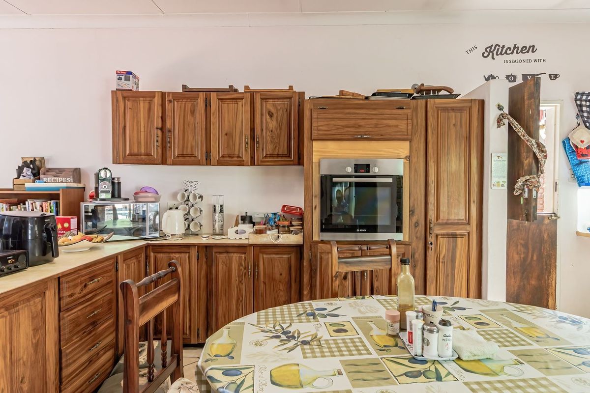 A functional kitchen featuring traditional wooden cabinetry, built-in oven, and ample counter space, offering a classic aesthetic with potential for modern updates.