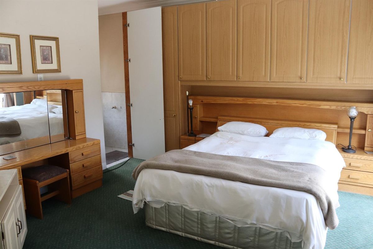 Bedroom featuring extensive built-in wooden cabinetry and an en-suite bathroom access.