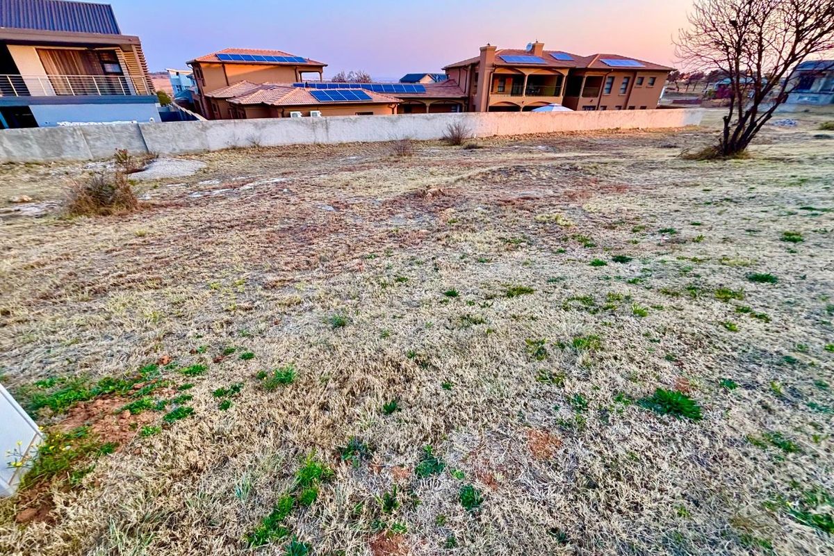 A vacant residential plot featuring a boundary wall, offering a clear space for potential development within an established neighborhood.