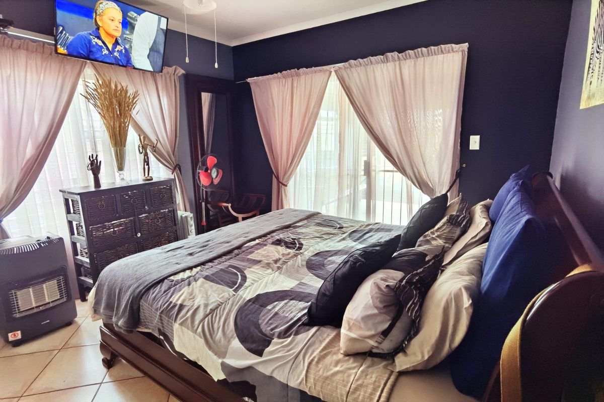 A bedroom featuring tiled flooring and a sliding glass door providing access to the exterior.