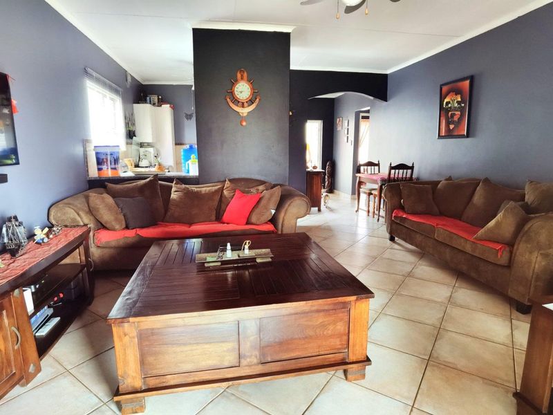 Open plan living area featuring tiled flooring, a central feature wall, and an archway leading to adjacent spaces.