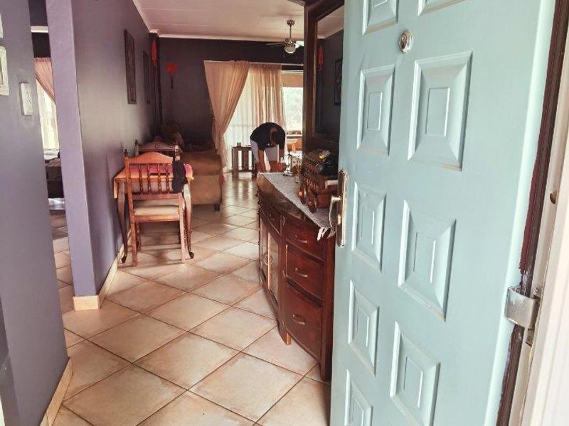 Entrance hallway featuring tiled flooring and an arched transition leading into the main living area.