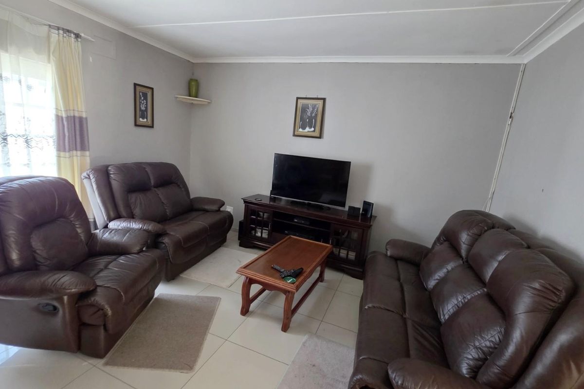 A functional living room featuring tiled flooring and neutral wall finishes, providing a comfortable and practical space for relaxation.