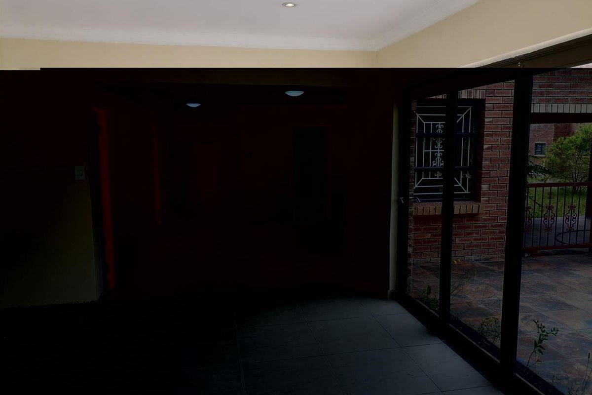 An interior living space featuring large sliding glass doors that provide access to an outdoor patio area.
