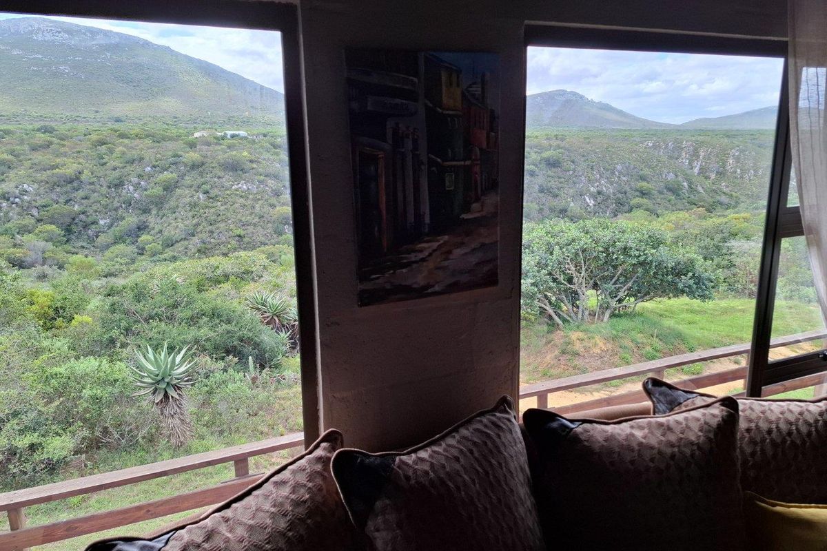 A living area featuring large windows that frame expansive views of the surrounding natural landscape and hills.