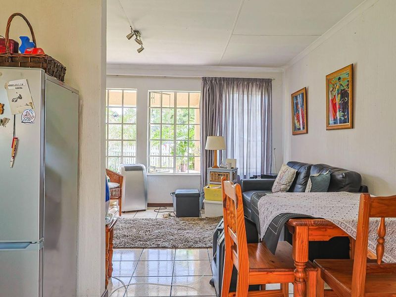 Open plan living and dining area featuring tiled flooring and large windows that provide natural light and access to the outdoor space.