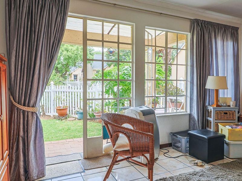 Living room featuring tiled flooring and large sliding glass doors providing direct access to the rear garden and patio area.