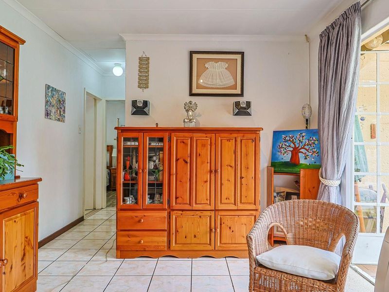 A living area featuring ceramic floor tiles and a sliding glass door providing access to the outdoor space.
