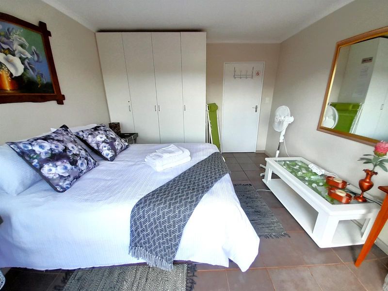 A functional bedroom featuring built-in cupboards and tiled flooring, providing a clean and practical living space.