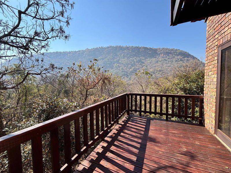 Elevated timber balcony featuring a wooden balustrade and direct access to the home, offering expansive mountain views.