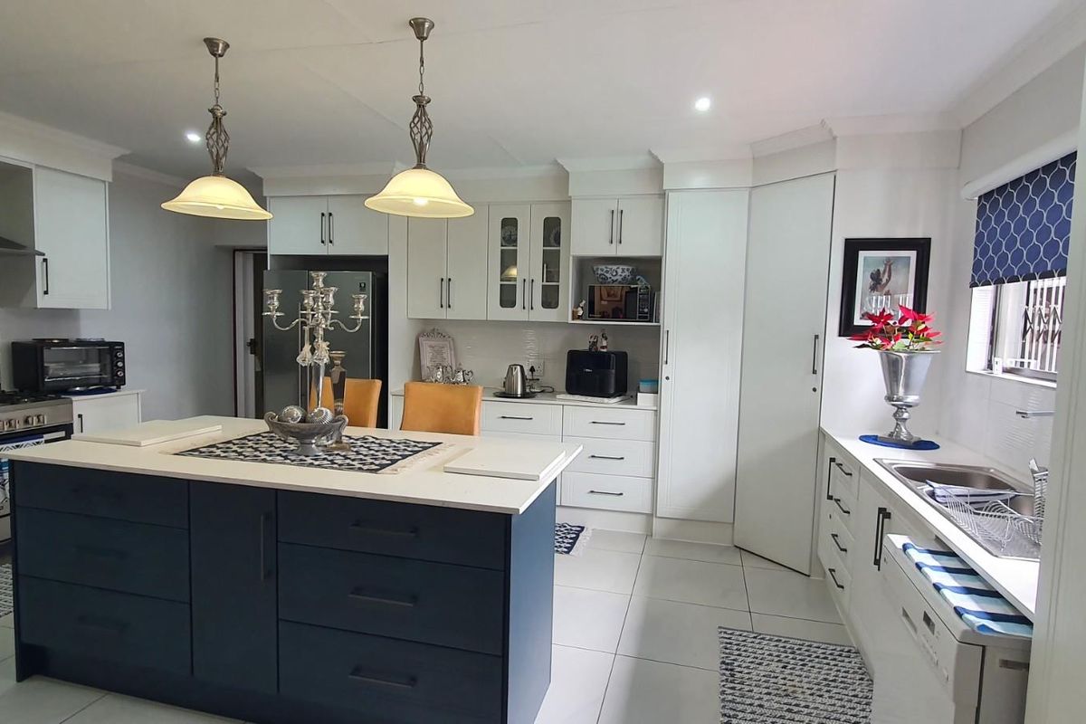 Modern kitchen featuring a central island, white cabinetry, stainless steel gas stove with extractor fan, and tiled flooring.