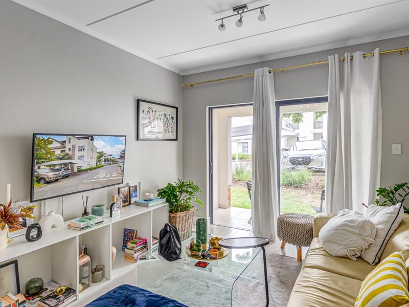 A bright living room featuring a sliding glass door that provides direct access to an outdoor patio area.