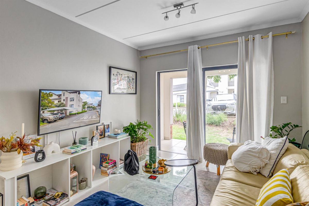 A bright living room featuring a sliding glass door that provides direct access to an outdoor patio area.
