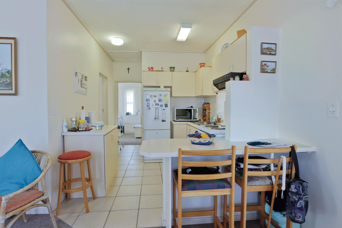 A functional kitchen area featuring built-in cabinetry, a breakfast bar, and tiled flooring, providing a practical layout for daily living.