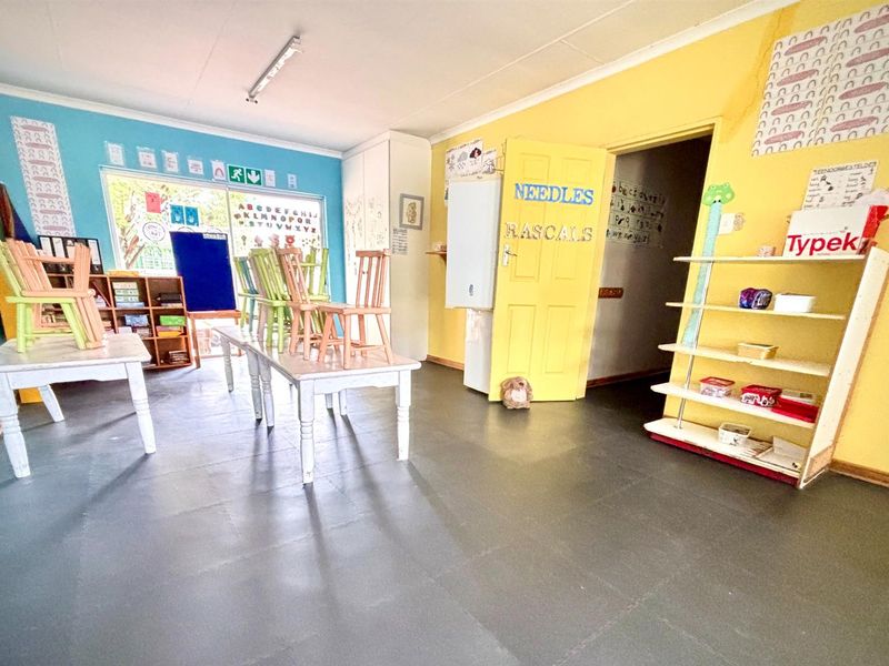 A functional classroom or office space featuring vinyl flooring, built-in shelving units, and bright wall finishes, suitable for educational or administrative use.