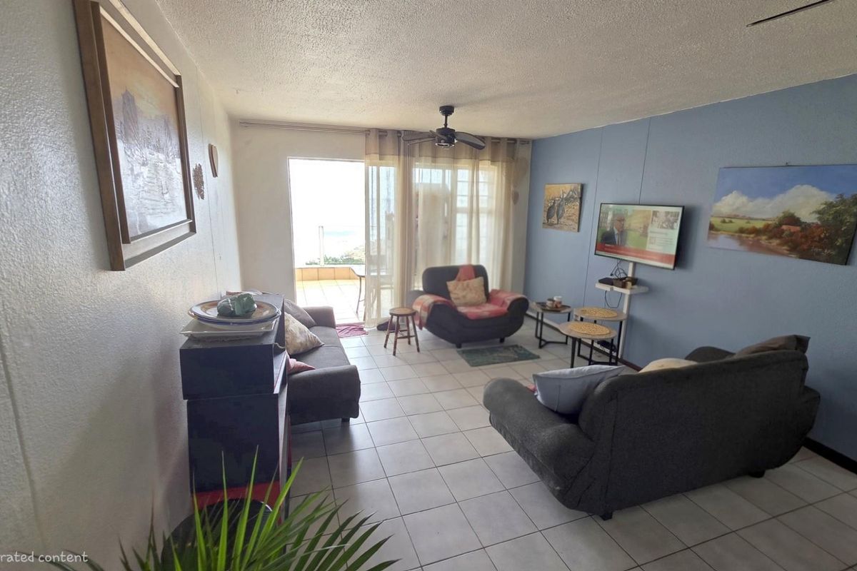 A living room featuring tiled flooring and a sliding glass door leading to an outdoor balcony area.