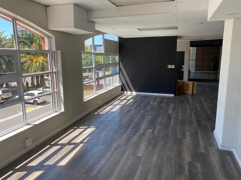 Bright and spacious open-plan office area featuring large windows, modern laminate flooring, and a clean, contemporary aesthetic suitable for various business configurations.