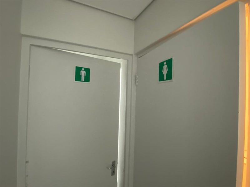 A hallway area featuring clearly marked male and female restroom entrances with white flush doors.