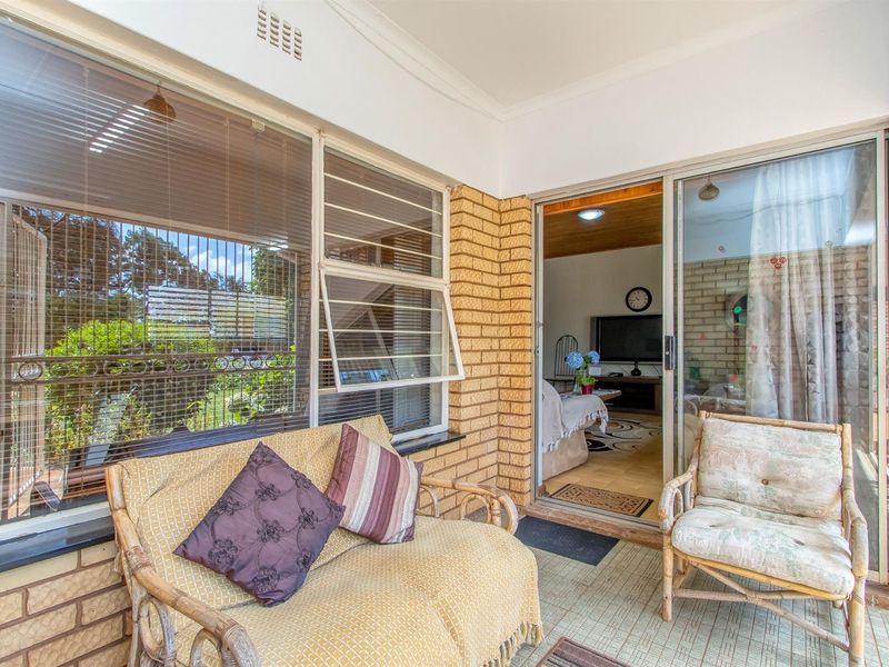 A covered patio area featuring face-brick walls and large sliding glass doors providing seamless access to the interior living space.