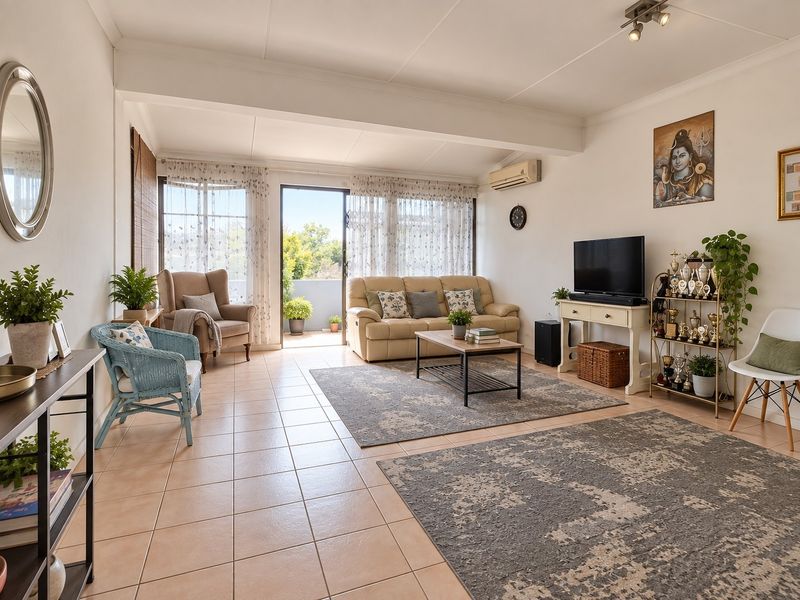 Spacious living room featuring tiled flooring, wall-mounted air conditioning, and direct access to an outdoor balcony through sliding glass doors.