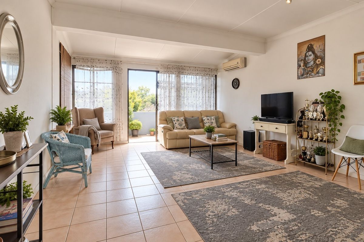 Spacious living room featuring tiled flooring, wall-mounted air conditioning, and direct access to an outdoor balcony through sliding glass doors.