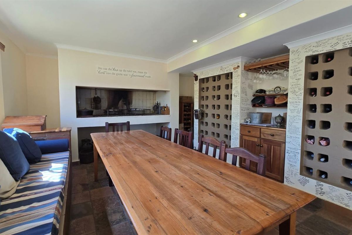 Entertainment area featuring a built-in indoor braai, custom wine storage shelving, and tiled flooring, ideal for hosting and social gatherings.