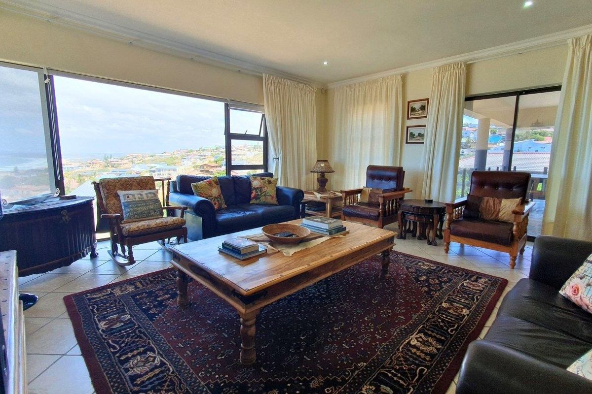 Spacious living room featuring large sliding glass doors that offer expansive coastal views and provide abundant natural light.