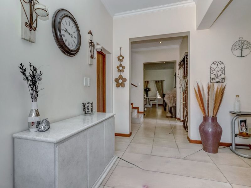 A bright entrance hallway featuring tiled flooring and an open archway leading to the interior living spaces.