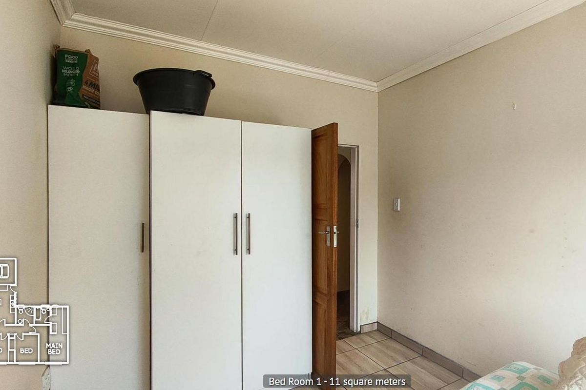 A bedroom featuring built-in wardrobes, tiled flooring, and coved ceilings, offering a functional space with potential for cosmetic updates.