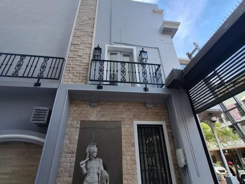 Front facade of the apartment building featuring stone cladding, a wrought iron balcony, and decorative architectural elements.