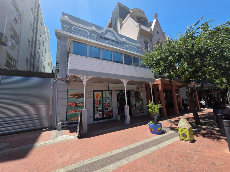 Street-level view of Tramway House, a historic building featuring an enclosed first-floor balcony and ornate iron veranda detailing on the ground floor entrance.