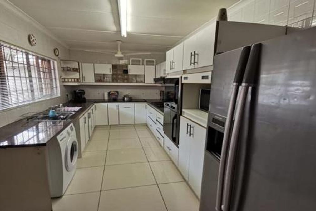 A functional kitchen featuring U-shaped cabinetry, granite countertops, built-in oven, and integrated laundry plumbing.