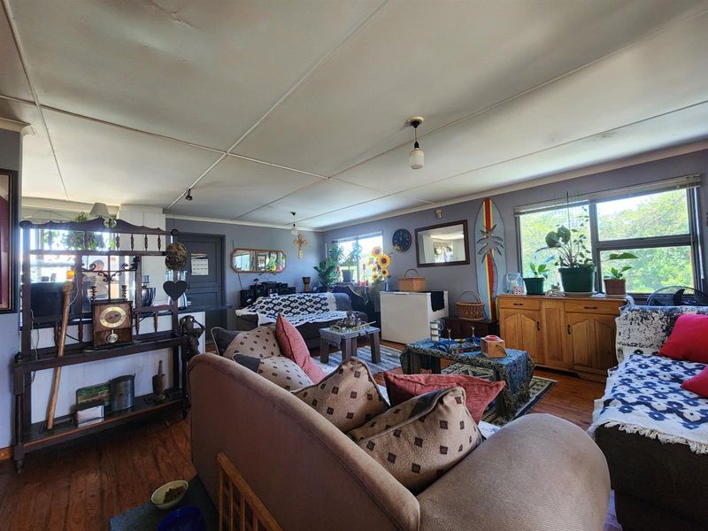 Spacious living room featuring timber flooring and large windows, offering a comfortable and functional layout for family relaxation.