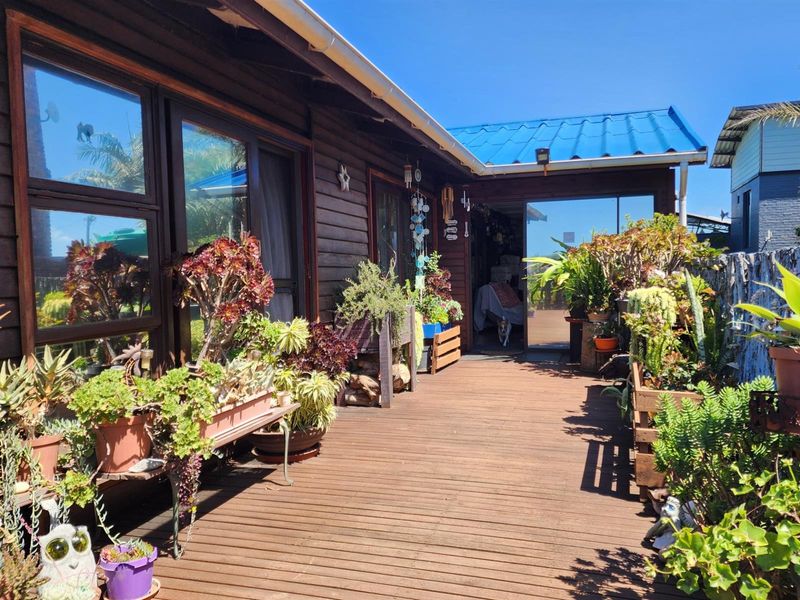 A timber deck patio area featuring large sliding glass doors, providing seamless indoor-outdoor flow to the rear of the property.