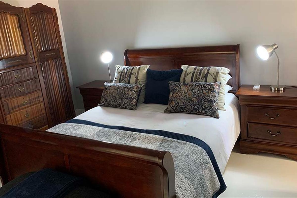 A standard bedroom featuring neutral wall finishes and tiled flooring.