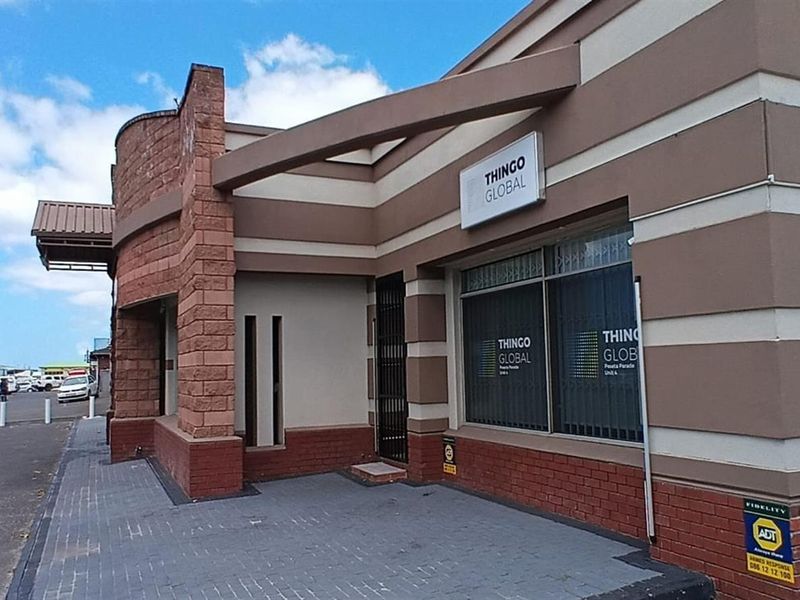 Front exterior view of a commercial property featuring brick facade, paved driveway, and security infrastructure.
