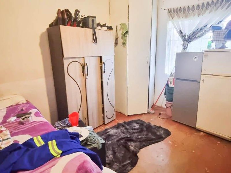 A bedroom featuring built-in wardrobe storage and security bars on the window, requiring cosmetic updates to improve the overall finish and appeal.