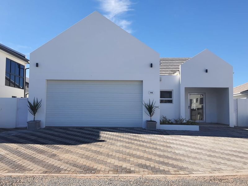 Modern single-story residential home featuring a clean white facade, double garage, and a neatly paved driveway.