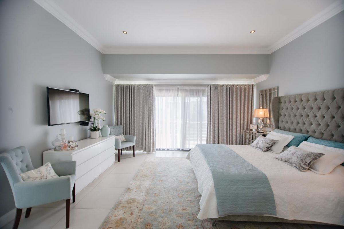 A well-maintained bedroom featuring recessed lighting, crown molding, and a sliding glass door providing natural light.