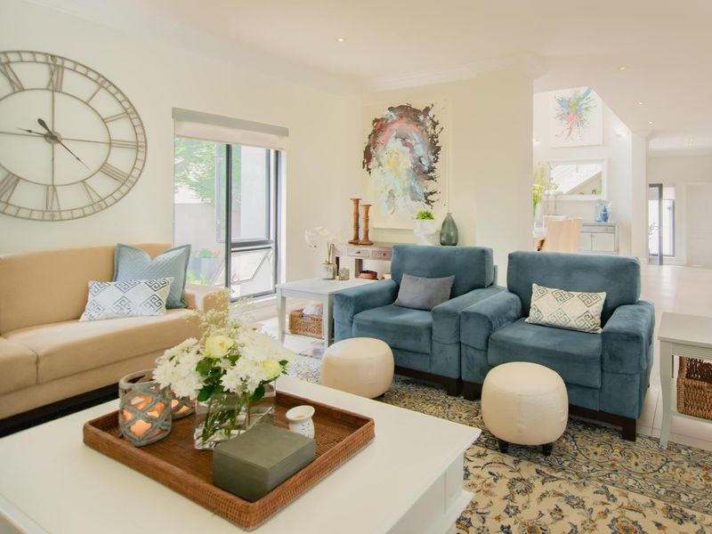 A bright and inviting living room featuring recessed downlighting, neutral wall finishes, and a sliding glass door providing access to the exterior.