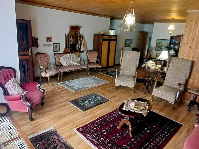 Spacious living area featuring warm timber ceiling and wall paneling with hardwood flooring, offering a traditional aesthetic.