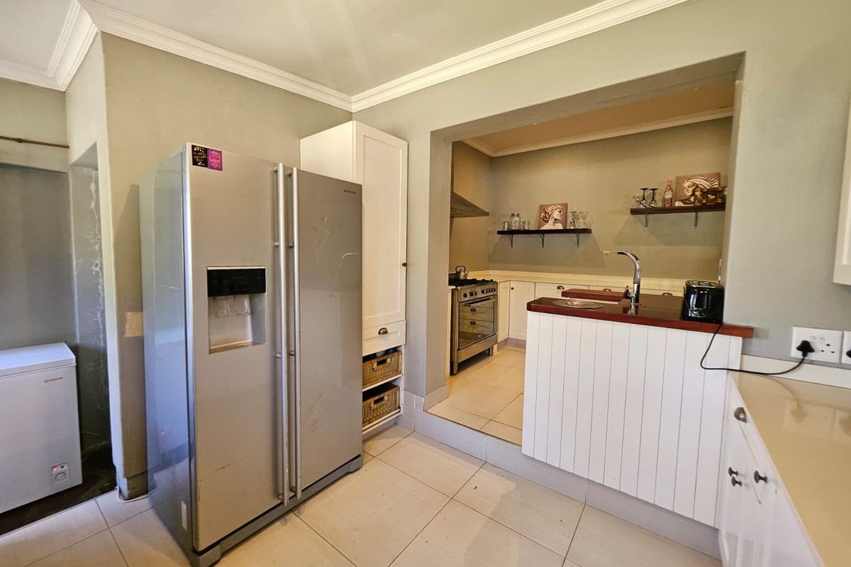 A functional kitchen featuring a split-level layout, built-in cabinetry, gas stove, and a breakfast bar with a sink.